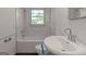 Clean bathroom with white tiling, sink, toilet, and a window at 111 Highway 138 E, Stockbridge, GA 30281