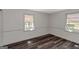 Bright bedroom featuring white walls, wood-look vinyl flooring and two windows at 111 Highway 138 E, Stockbridge, GA 30281
