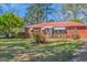 Well-kept brick home with awnings, landscaped front yard, and red metal roof at 111 Highway 138 E, Stockbridge, GA 30281