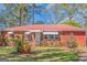 Brick ranch-style home with red metal roof, awnings and a meticulously maintained front yard at 111 Highway 138 E, Stockbridge, GA 30281