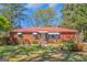 Charming brick ranch-style home featuring a red metal roof and a well-maintained front yard at 111 Highway 138 E, Stockbridge, GA 30281