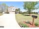 Spacious front yard with manicured lawn and driveway leading to a two-story home with stone and siding exterior at 116 Ducati Dr, Mcdonough, GA 30252
