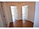Hallway featuring hardwood floors with door entryways to rooms in home at 116 Ducati Dr, Mcdonough, GA 30252