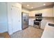 Well-lit kitchen with stainless steel appliances, white cabinets, tiled backsplash and tiled floors at 116 Ducati Dr, Mcdonough, GA 30252