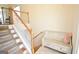 Carpeted staircase with a wooden railing and a charming bench seat on the landing at 116 Ducati Dr, Mcdonough, GA 30252