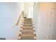 Carpeted stairway with a wood handrail leading to the upper level of the home at 116 Ducati Dr, Mcdonough, GA 30252