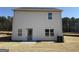 Spacious backyard featuring a rear entry door, multiple windows and bordered by a tranquil wooded area at 571 Cantrell Drive, Dallas, GA 30157