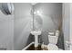 This charming powder room features a pedestal sink, toilet, stylish mirror, and elegant wall fixtures at 6870 Diamond Dr, Rex, GA 30273