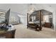 Spacious bedroom with a four-post bed, seating area, and carpeted floors at 6870 Diamond Dr, Rex, GA 30273