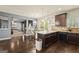 This spacious kitchen features dark wood cabinets, granite countertops, a breakfast bar and a view into the living space at 6870 Diamond Dr, Rex, GA 30273