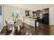 Kitchen dining area boasts modern light fixtures, wooden floors, and stainless steel appliances at 6870 Diamond Dr, Rex, GA 30273
