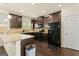 Charming kitchen featuring dark wood cabinets, granite counters, a black refrigerator, oven, and a door leading outside at 6870 Diamond Dr, Rex, GA 30273
