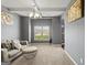 Comfortable seating area with a large window offering outdoor views, soft neutral carpet, and coffered ceiling at 6870 Diamond Dr, Rex, GA 30273