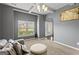 A well-lit sitting area with comfortable seating, a large window, neutral carpet, and coffered ceiling at 6870 Diamond Dr, Rex, GA 30273