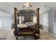 The main bedroom has an elaborate four-poster bed with detailed wood carvings and neutral carpet at 6870 Diamond Dr, Rex, GA 30273