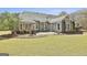 Grassy backyard showcasing the home's exterior, patio area, and professionally landscaped garden beds at 410 Denton Cir, Fayetteville, GA 30215