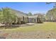 Wide backyard showing patio, landscaping, and rear home exterior with neutral siding and well maintained lawn at 410 Denton Cir, Fayetteville, GA 30215