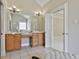 Bathroom featuring dual sinks, wood cabinets, granite countertops, and large mirrors at 410 Denton Cir, Fayetteville, GA 30215