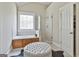 Bright bathroom with a soaking tub, a glass enclosed shower, and a decorative window at 410 Denton Cir, Fayetteville, GA 30215