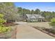 Well-maintained home with lush landscaping and a long driveway leading to the attached garage at 410 Denton Cir, Fayetteville, GA 30215