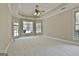 Spacious main bedroom with carpet, large windows, tray ceiling, and a ceiling fan at 410 Denton Cir, Fayetteville, GA 30215