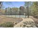 View of a well-maintained community tennis court enclosed with fencing and walkway access at 410 Denton Cir, Fayetteville, GA 30215
