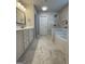 Bright bathroom featuring double vanity, marble tile flooring, and a luxurious bathtub with shower at 2470 Wevok Way, Grayson, GA 30017