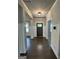 Elegant foyer with dark hardwood flooring, white wainscoting, and a stylish light fixture at 2470 Wevok Way, Grayson, GA 30017