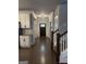 Bright hallway with hardwood floors, white trim and view to the kitchen and front door at 2470 Wevok Way, Grayson, GA 30017