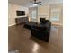 Open-concept living room with a gray sofa, entertainment center, and hardwood flooring at 2470 Wevok Way, Grayson, GA 30017
