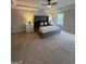 Main bedroom showcasing a tray ceiling, ceiling fan, new carpeting, and a large window at 2470 Wevok Way, Grayson, GA 30017