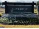 Silverton: A Starlight Homes community sign with flowers and protective netting adorning the entrance at 2369 Argento Cir, Dacula, GA 30019