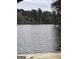 Scenic view of the lake with mature trees lining the shore and a small dock perfect for enjoying waterfront living at 2527 Amalfi Dr, Conyers, GA 30012