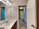 Bright bathroom with a vanity, sink, and mirror, leading to a hallway with other rooms at 3713 Upland Dr, Mcdonough, GA 30253