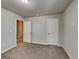 A simple bedroom with neutral walls and carpet flooring, features a closet and doorway at 3713 Upland Dr, Mcdonough, GA 30253