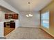 Cozy dining area adjacent to kitchen, featuring a modern chandelier and ample natural light from a large window at 3713 Upland Dr, Mcdonough, GA 30253