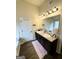 Bathroom featuring double sinks, a large mirror, wood floors, and modern lighting fixtures at 2275 Church St, Hampton, GA 30228