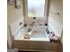 Bathroom with a soaking tub with a small window, tile surround, and a wood caddy at 2275 Church St, Hampton, GA 30228