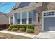 Charming two-story home with a one-car garage, blue siding, brick accents, and landscaped front yard at 108 Mulberry Ct, Peachtree City, GA 30269