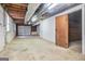 Unfinished basement with concrete floor, exposed ceiling, and access to a garage door at 4230 Iris Brooke Ln, Snellville, GA 30039