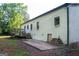 Back view of home with a deck and stairs leading to a patio area, surrounded by trees and natural landscape at 281 New Hope Dr, Mcdonough, GA 30252