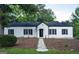 Charming white brick home featuring black shutters and a welcoming walkway to the front door at 281 New Hope Dr, Mcdonough, GA 30252