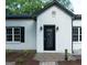 Charming home featuring a striking black front door with a brick pathway and manicured landscaping at 281 New Hope Dr, Mcdonough, GA 30252