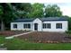 Beautiful single-story home with a black roof, white brick, black shutters and a stone pathway at 281 New Hope Dr, Mcdonough, GA 30252