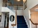 Staircase with wood railing, blue carpet, and an open view of the second floor hallway at 233 Mistybrook Cir, Stone Mountain, GA 30087