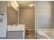 This bathroom is complete with a large mirror, tub, tiled floors and good lighting at 130 Bradley Pl, Mcdonough, GA 30253