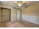 A carpeted bedroom with neutral paint features a ceiling fan and closet for storage at 130 Bradley Pl, Mcdonough, GA 30253