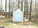 Outdoor storage shed in a wooded backyard offers extra space for tools and equipment at 40 Pebble Brooke Ct, Covington, GA 30016