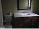Bathroom with dark wood vanity and a white sink, toilet and mirror at 6733 Jojanne Ln, Lithonia, GA 30038