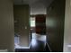 Hallway view into kitchen with dark cabinets, stone tile backsplash, stainless microwave, and tile flooring at 6733 Jojanne Ln, Lithonia, GA 30038